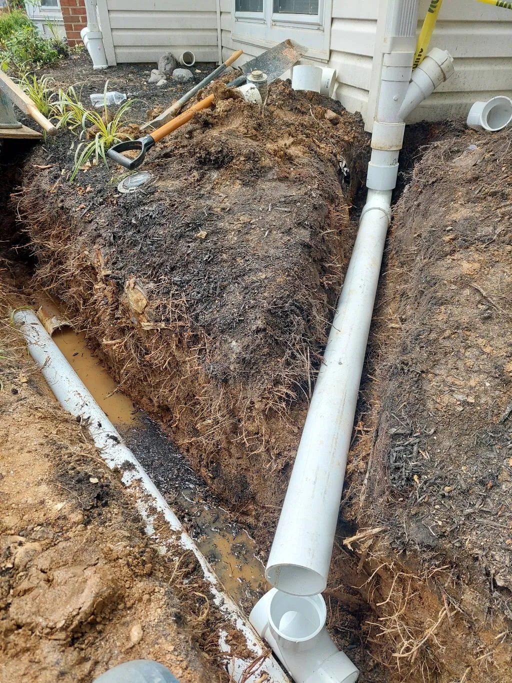 Water pooling near a home's foundation after heavy rainfall, showing signs of poor yard drainage